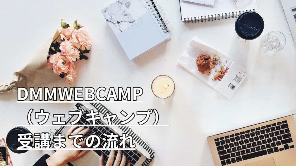 机の上にパソコン、ノート、花などが置いてある