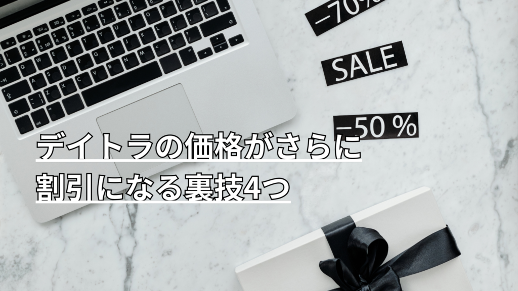 大理石調のテーブルの上にノートパソコンのキーボードと、"SALE""-70%""-50%"のラベルが置かれている