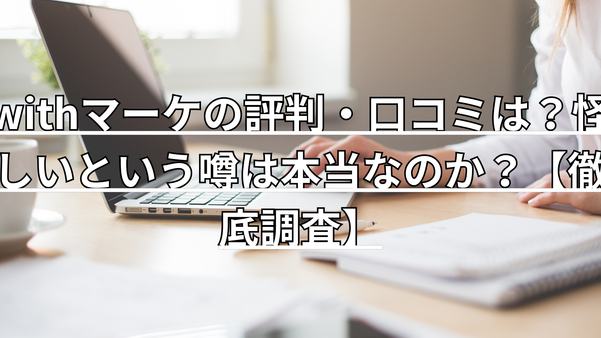 テーブルでノートを広げながらパソコンを使っています
